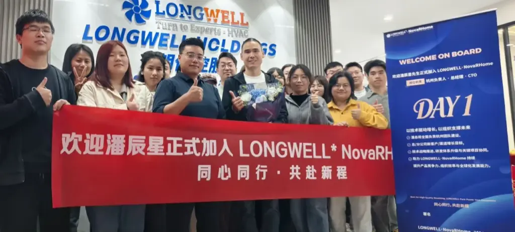 LONGWELL 杭州团队在品牌墙前手持红色欢迎横幅合影，右侧摆放蓝色欢迎展架