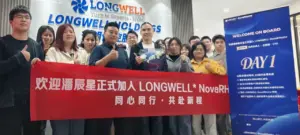 LONGWELL 杭州团队在品牌墙前手持红色欢迎横幅合影，右侧摆放蓝色欢迎展架
